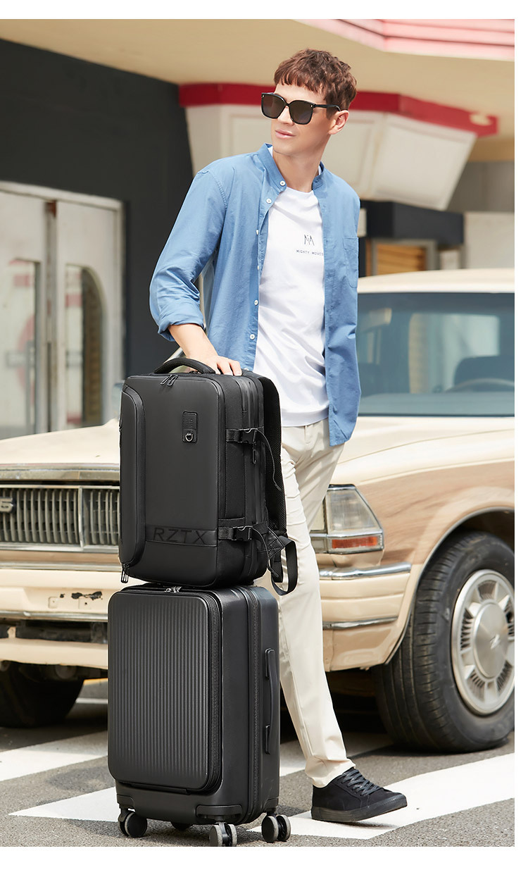 backpack's integrated luggage strap fitted over a rolling suitcase handle