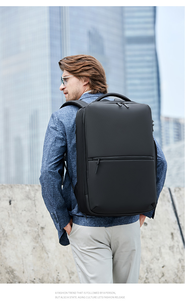 model wearing the backpack from behind against glass buildings