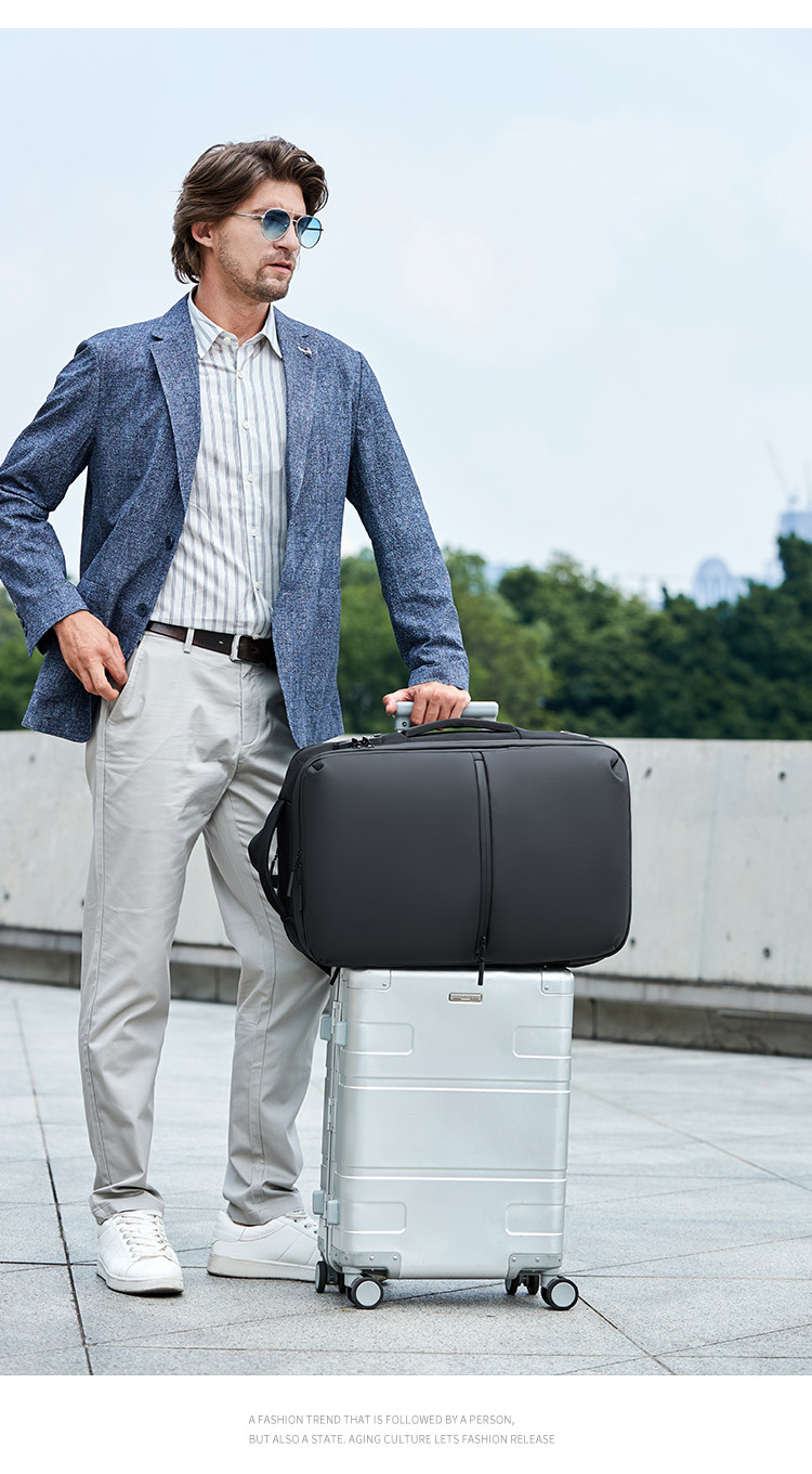 model holding the backpack stacked on a rolling suitcase