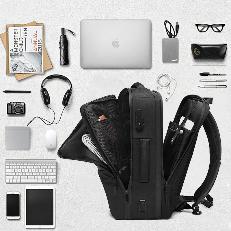 flat-lay of backpack with laptop, phone, camera, and travel accessories